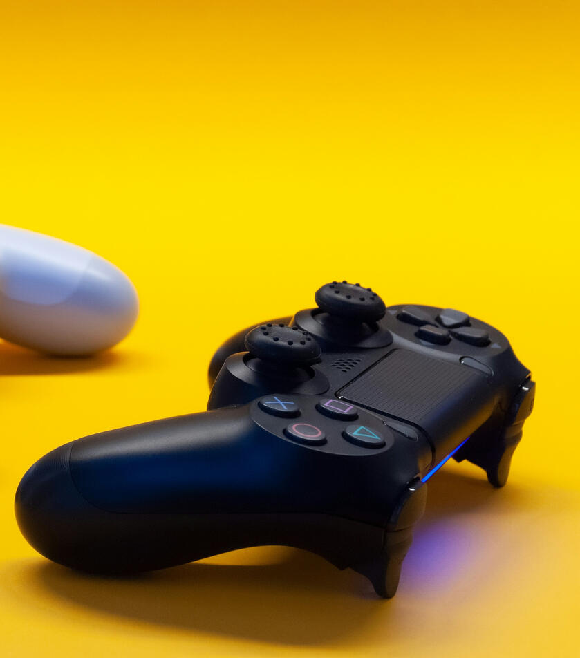 A video game controller in a yellow background.