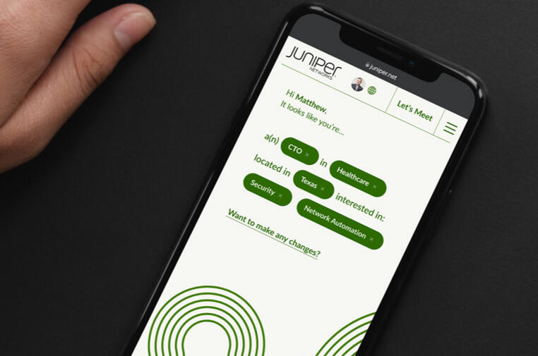 A close up image of a hand holding an iPhone showing the reimagined experience of Juniper's homepage for a new customer.
